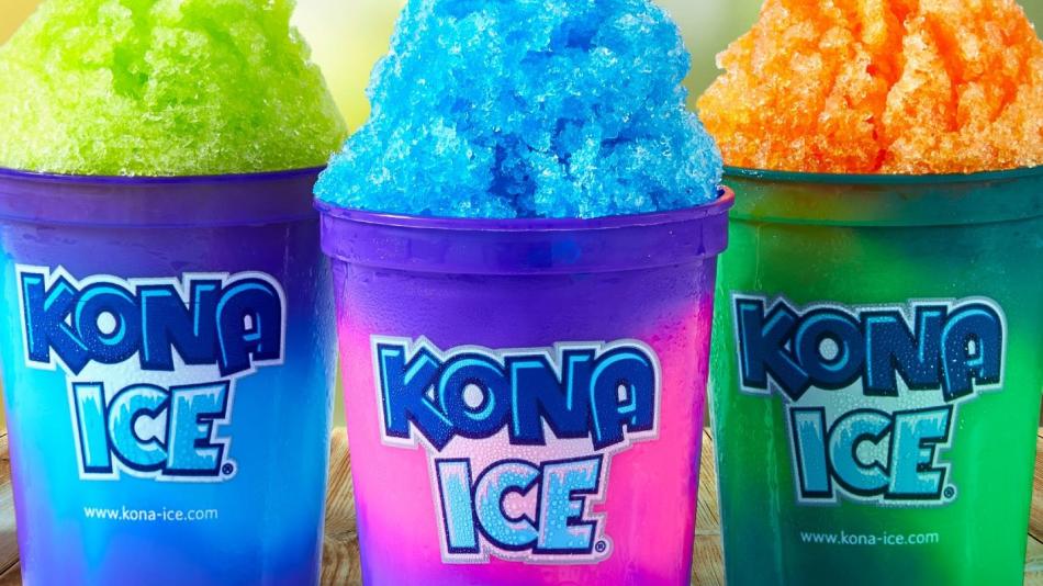 Three colorful cups of shaved Kona ice are placed on a rustic wooden table.